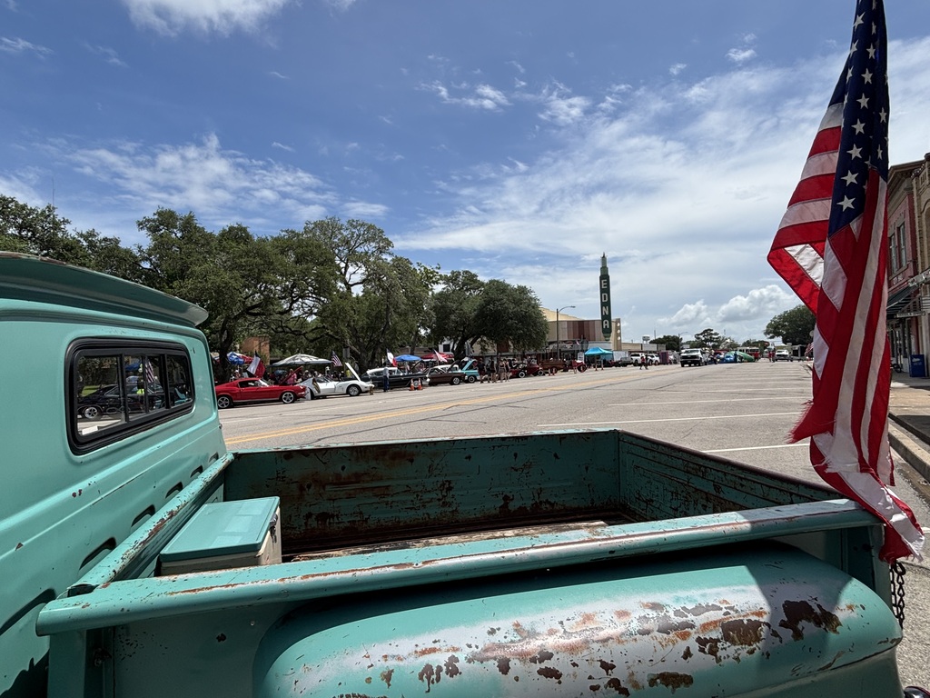 flag adorns a vintage truck in downtown Edna