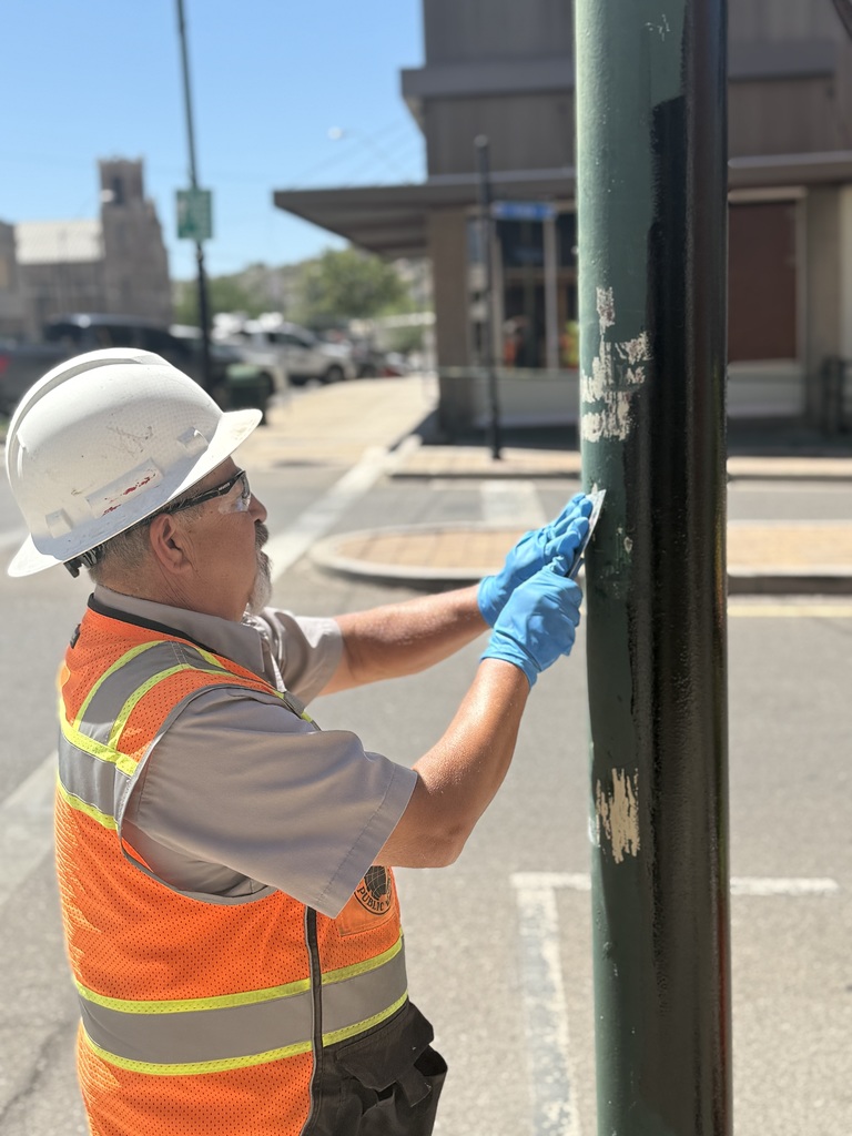 City staff hard at work painting light poles in Downtown Globe