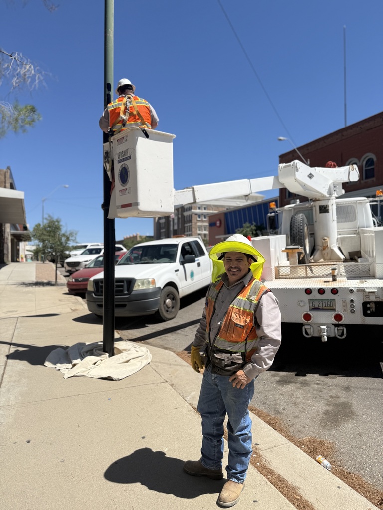 City staff hard at work painting light poles in Downtown Globe
