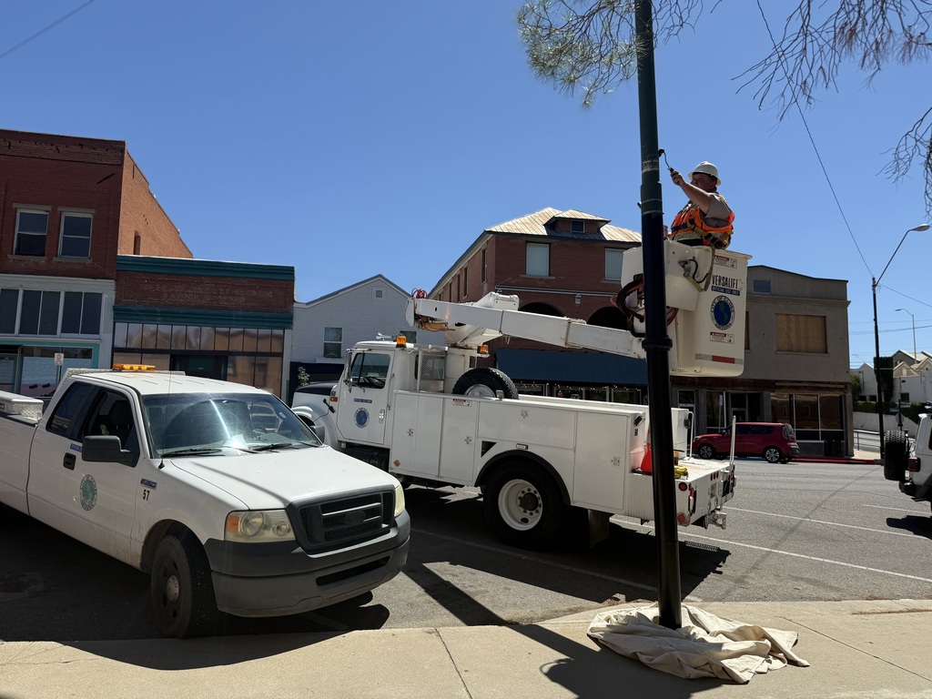 City staff hard at work painting light poles in Downtown Globe