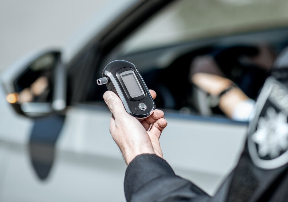 Image of police officer holding a breath testing device