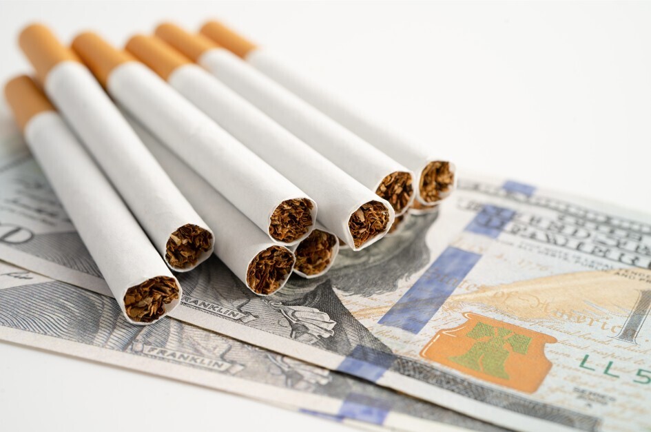 Image of cigarettes on top of U.S. Currency