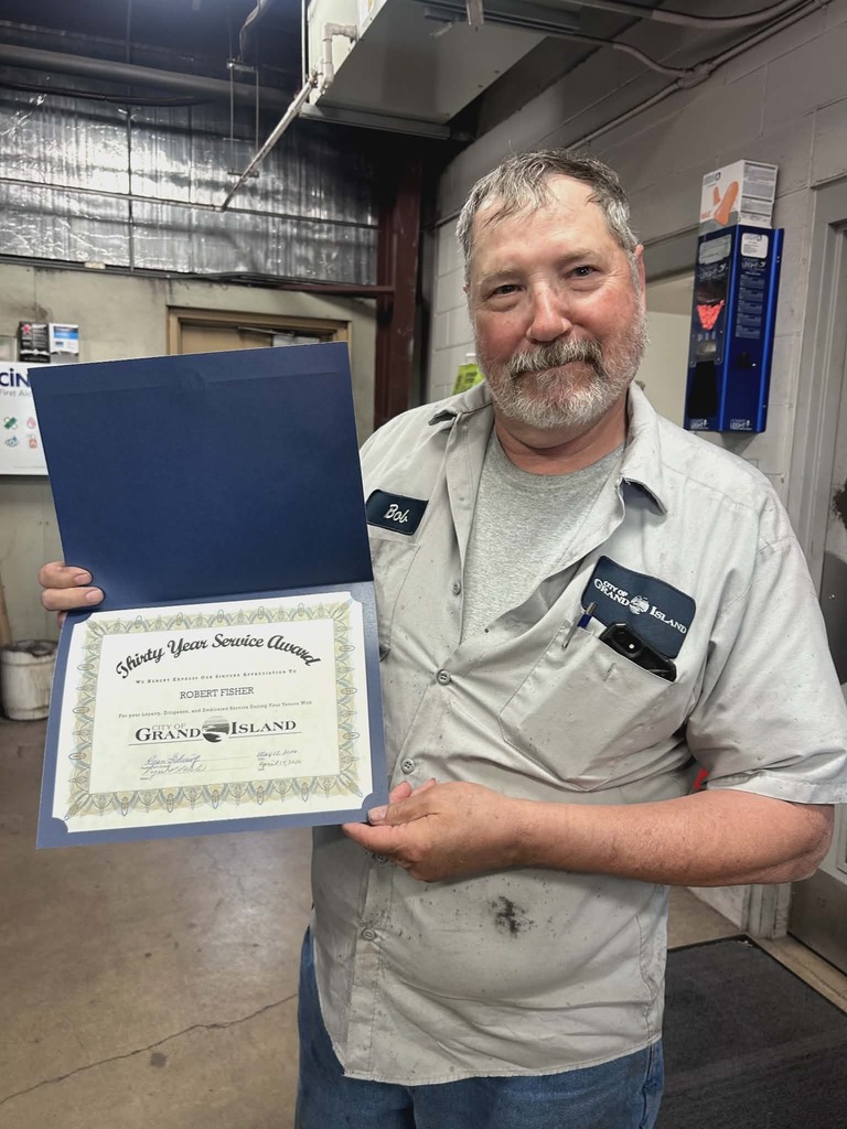 Bob Fisher holding up his 30-year anniversary certificate