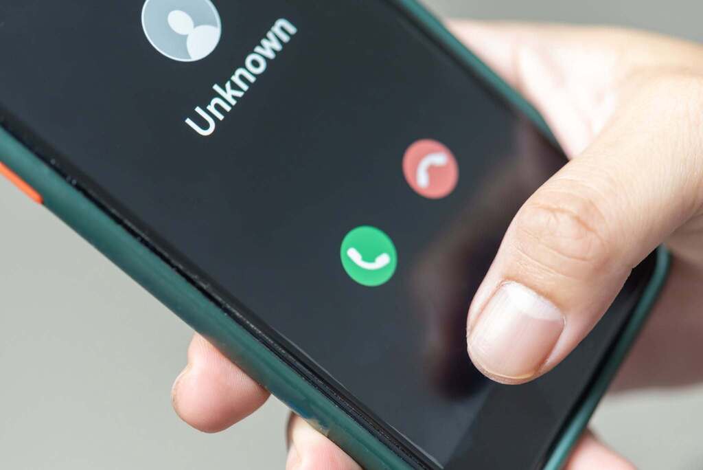 Someone holding a phone as an unknown call comes in