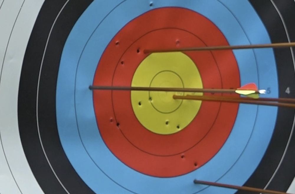 picture of several arrows stuck in a colorful archery target