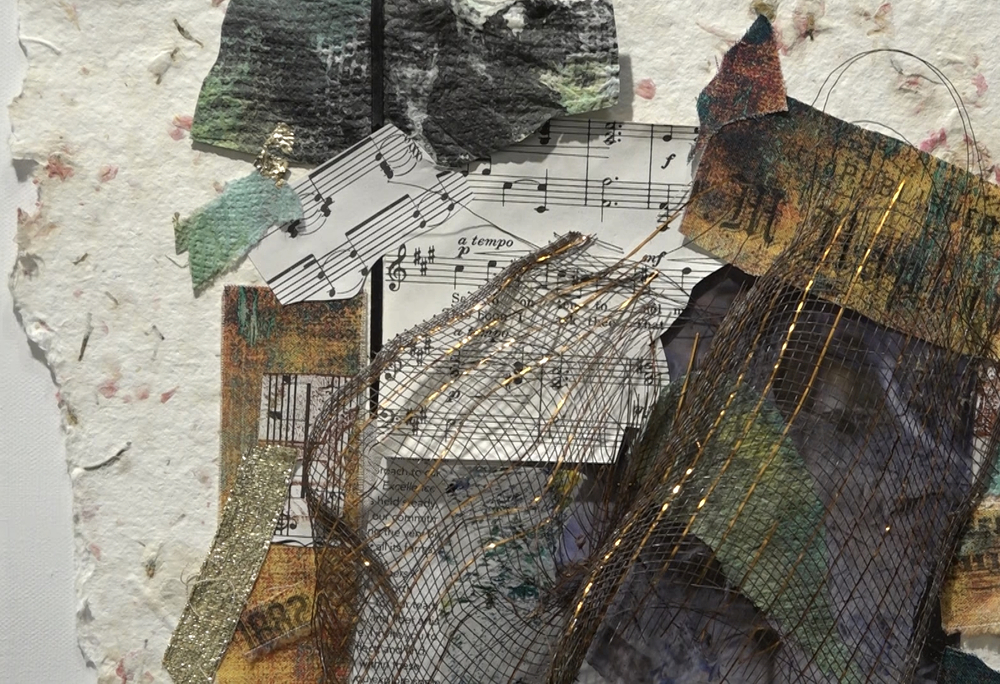 Tight shot of a piece of fiber art that contains ribbon of various colors and texture as well as layered paper