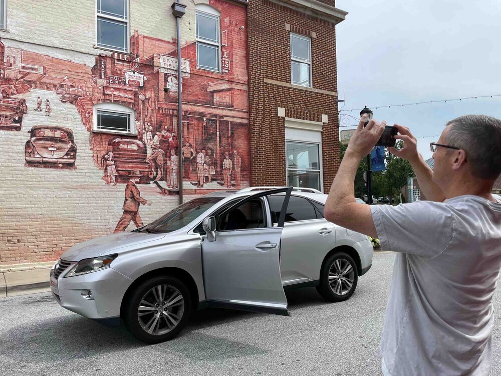 Man takes picture of Mural with phone