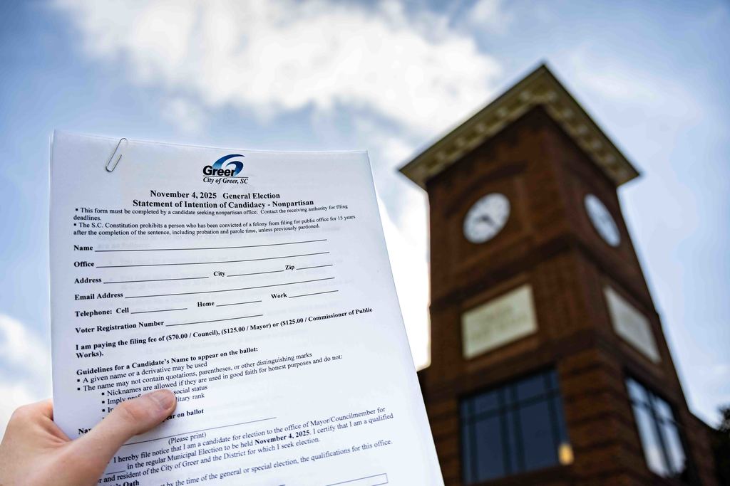 Hand Holding up Election Filing Papers in Front of Greer City Hall