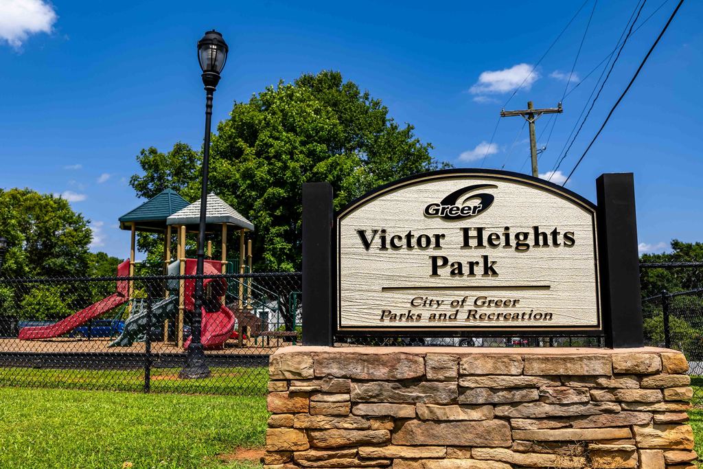 Victor Heights Park Sign with Playground in Background