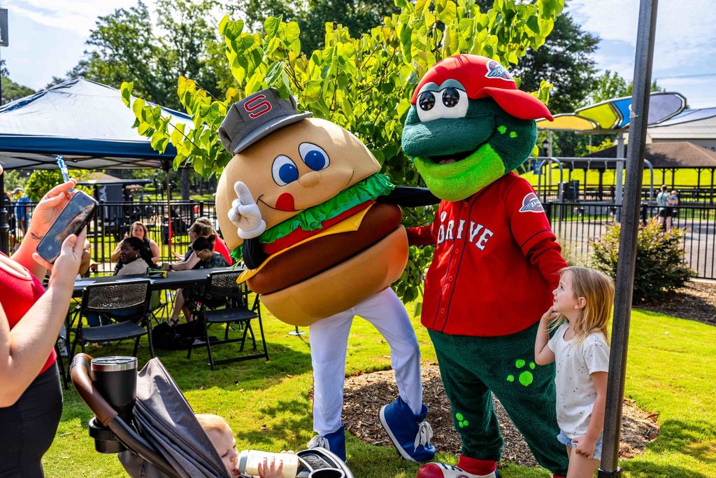 Chuck from the Hub City Spartanburgers and Reedy Rip'it from the Greenville Drive pose for picture with little girl