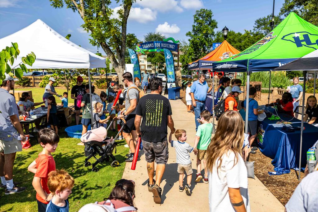 Families walk through Kids Planet Park during Park Hop Playdate