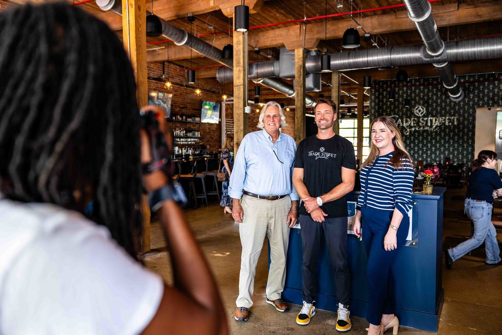 Photographer takes Picture of Mayor Danner, Katie Collins from the Greer Chamber of Commerce, and the Owner of Trade Street Social