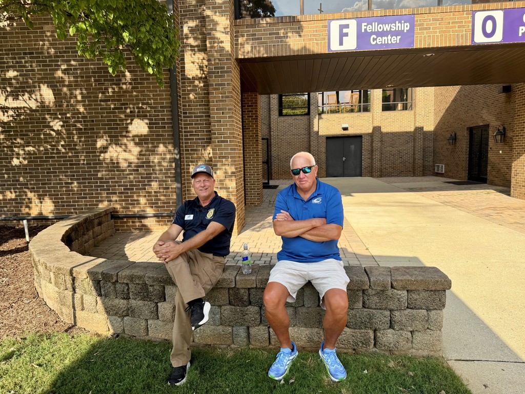 two men sitting outside of the meeting