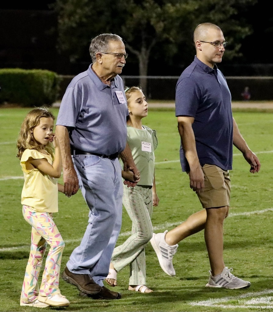 carl walking on field with family