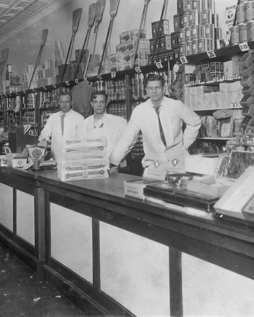old photo of men behind shop counter