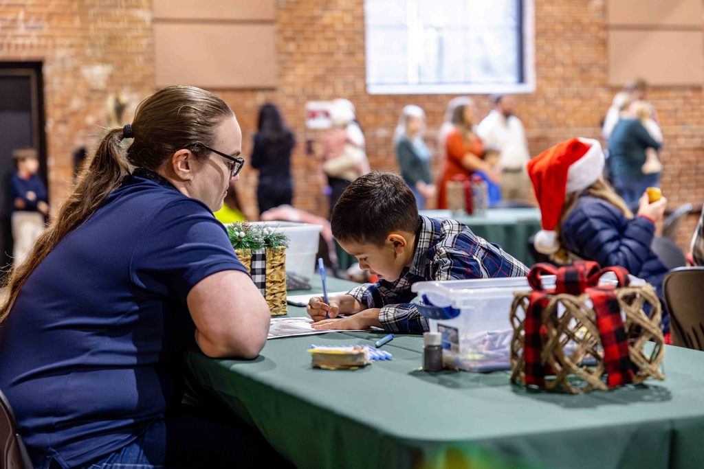Boy fills out letter to Santa at Breakfast with Santa