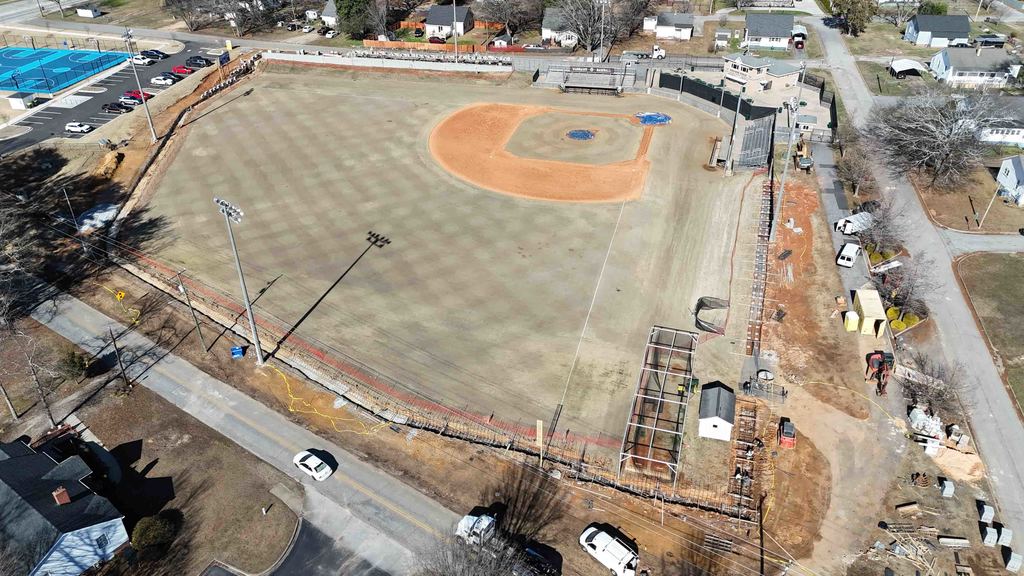 Drone shot over a baseball field with active construction around the perimeter 
