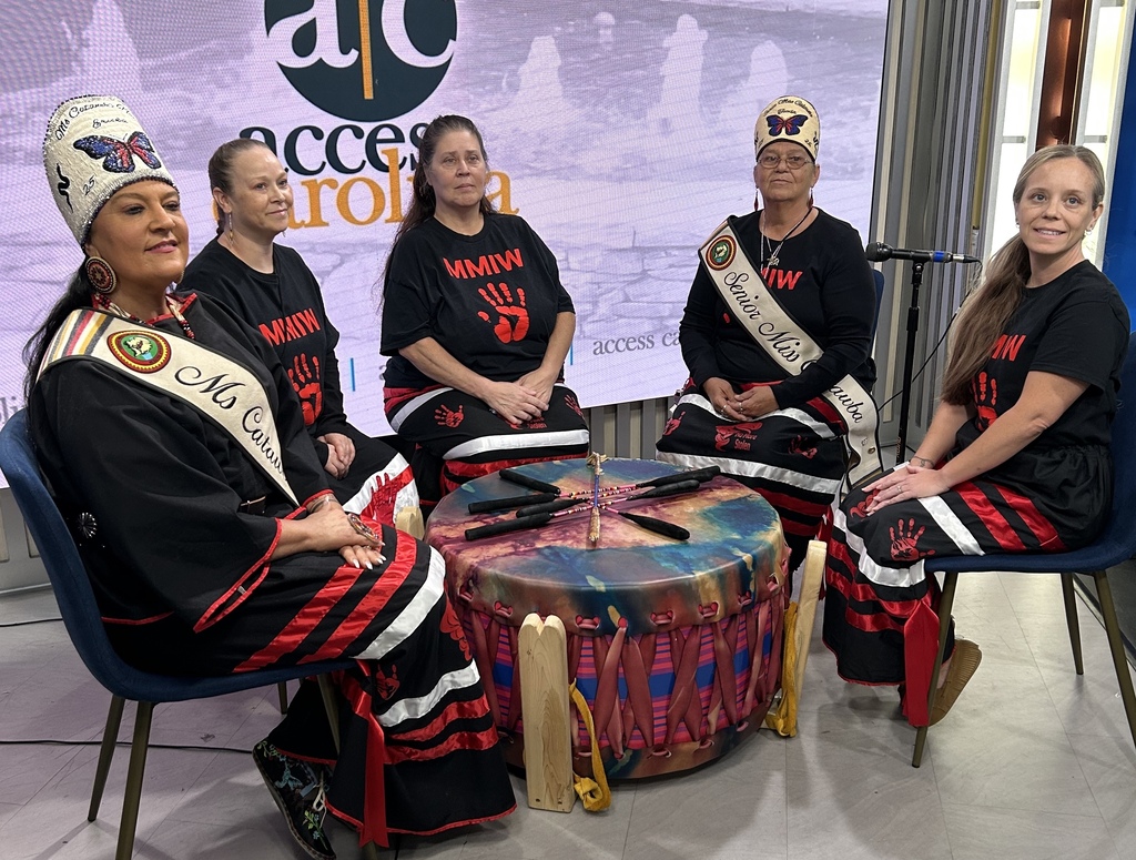 Picture shows women from the Catawba Nation sitting in chairs around a large drum