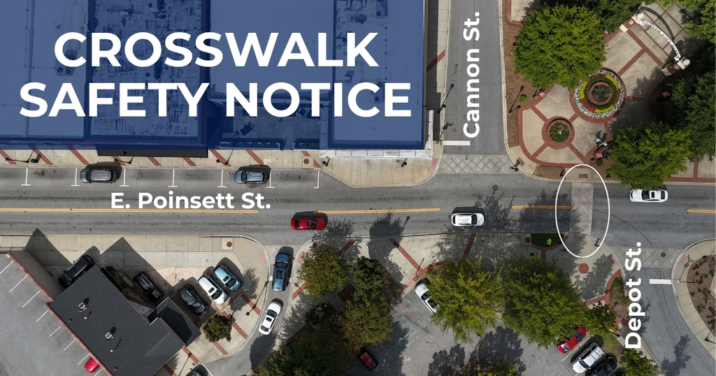 Drone shot of the intersection of E. Poinsett, Cannon, and Depot St. The crosswalk leading to the entrance of Greer City Park is circled. The title is Crosswalk Safety Notice. 