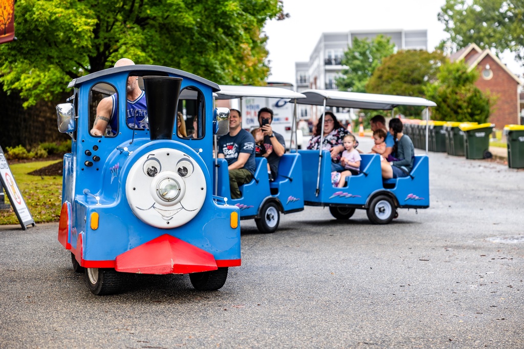 Picture of a Thomas the Tank Engine amusement ride full of people riding through Greer City Park