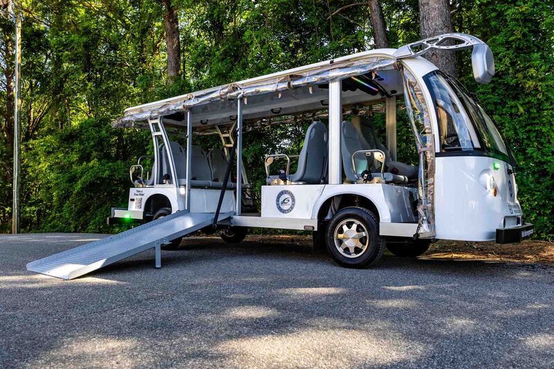 White shuttle with wheelchair ramp and trees in the background