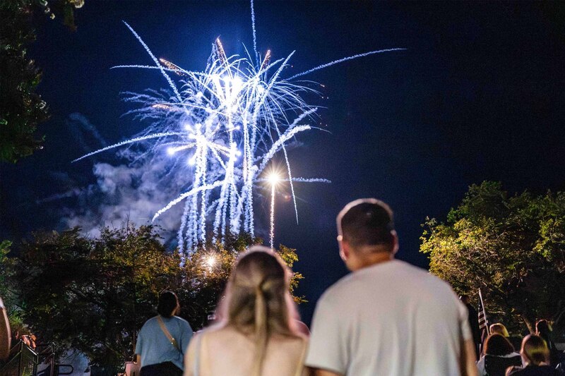 Blue Fireworks Light Up Sky as Couple Watches