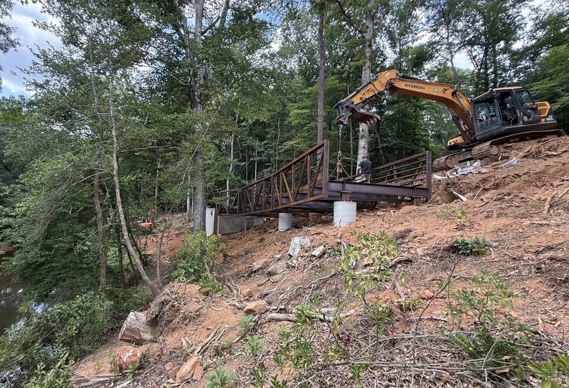 Picture shows a digger and the metal framing of a boardwalk being built along the new S. Tyger River trail