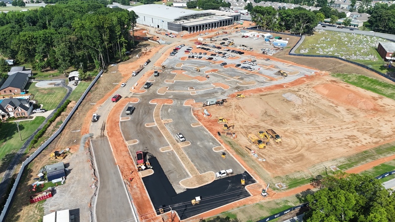 Drone shot of the parking lot paving in progress with the Sports and Events Center in the background