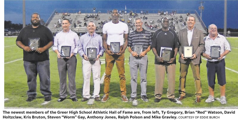 Picture features the 2018 Athletics Hall of Fame inductees on the football field holding plaques