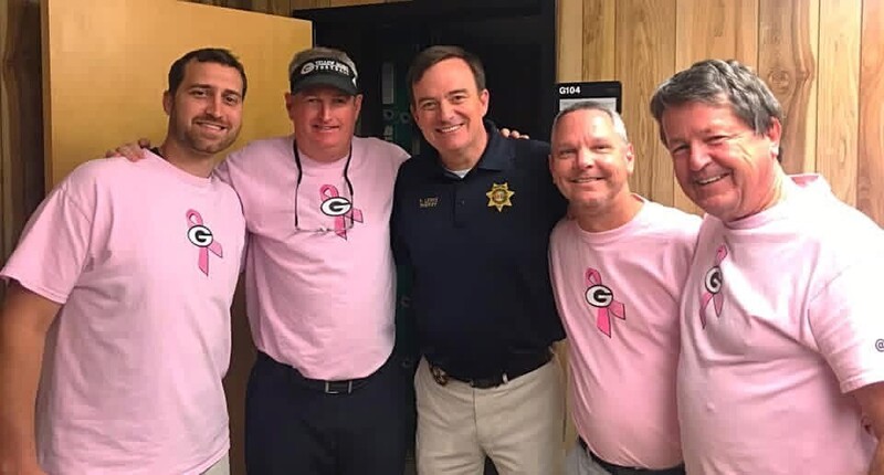 four men in pink shirts standing with the Greenville County Sheriff