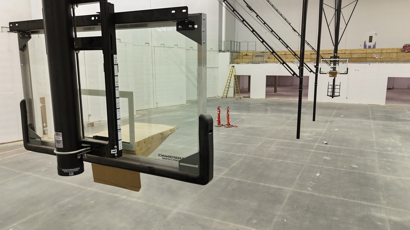 View of the championship arena in the Prisma Health Performance Center from behind one of the new basketball goals looking down the length of the gym to the other side of the court