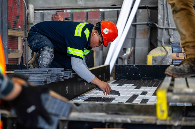 Worker hand placing bricks into a wall mold