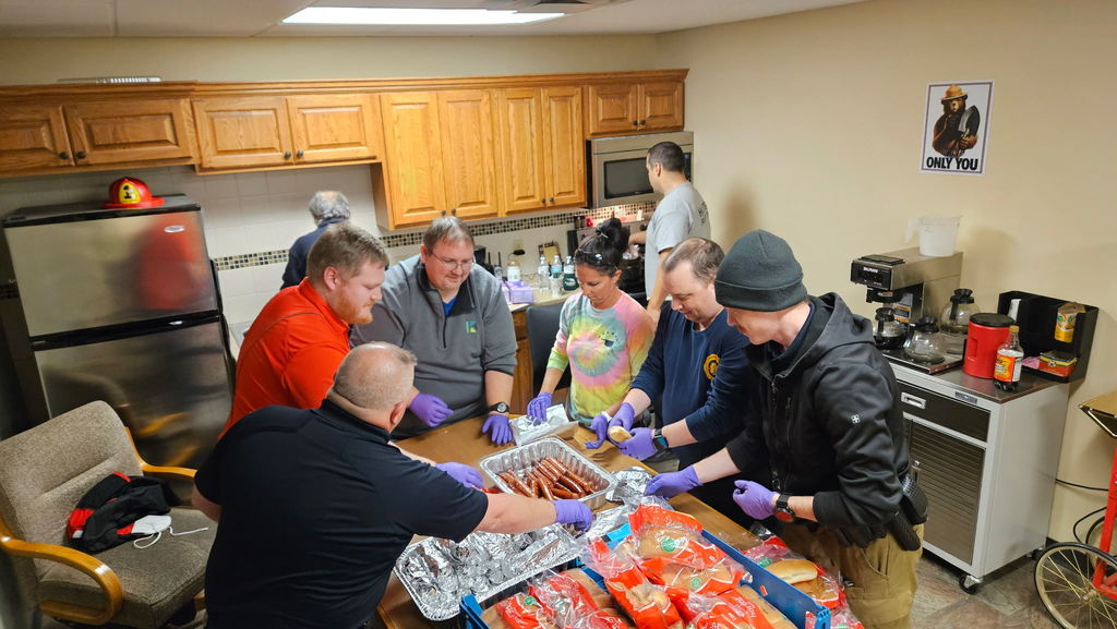 group of people assembling hot dogs to eat