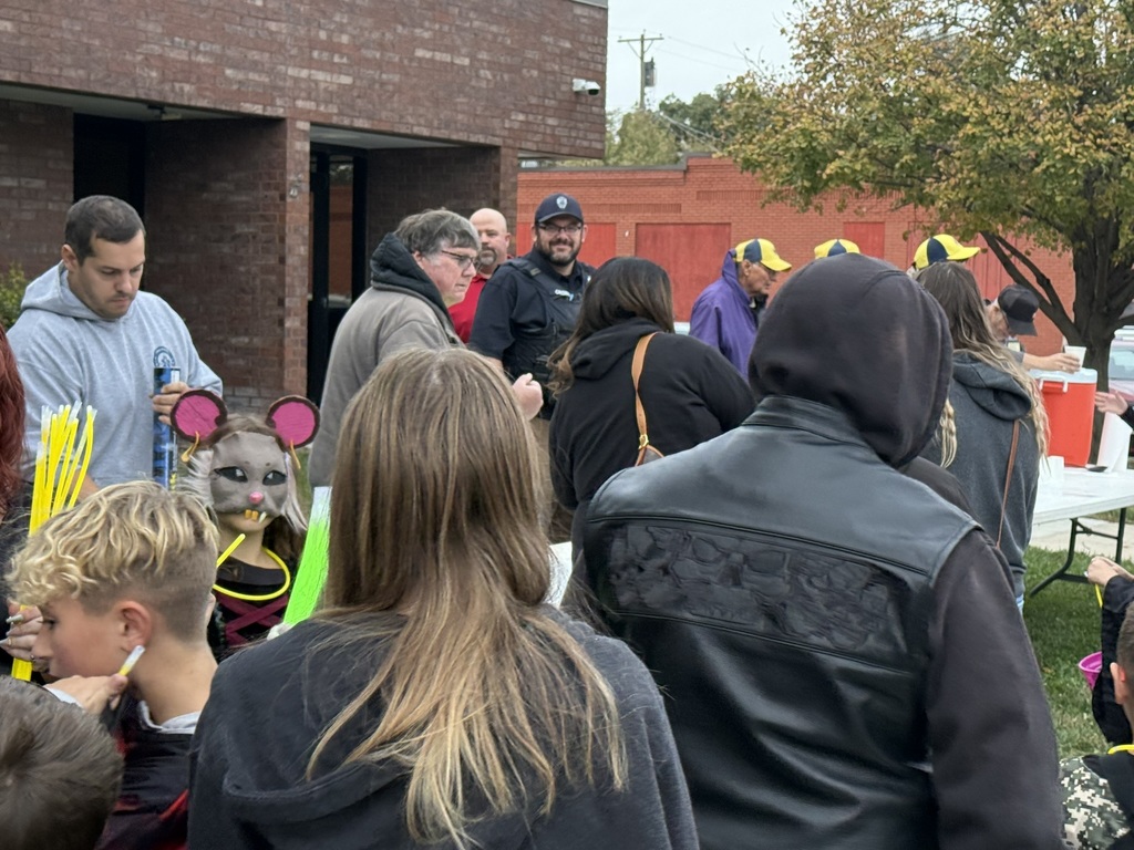 people passing out hot dogs to trick or treaters