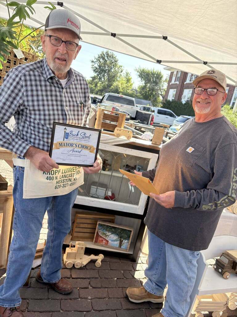 Milferd Dirks (artist) and James VanSchaick (Council President) with the Mayor's Choice for the 2026 Brick street Arts & Crafts Festival.