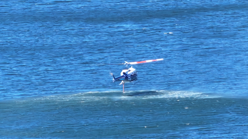 firefighting helicopter pulls water from the Columbia River on 8/21 during Kalama wildfire