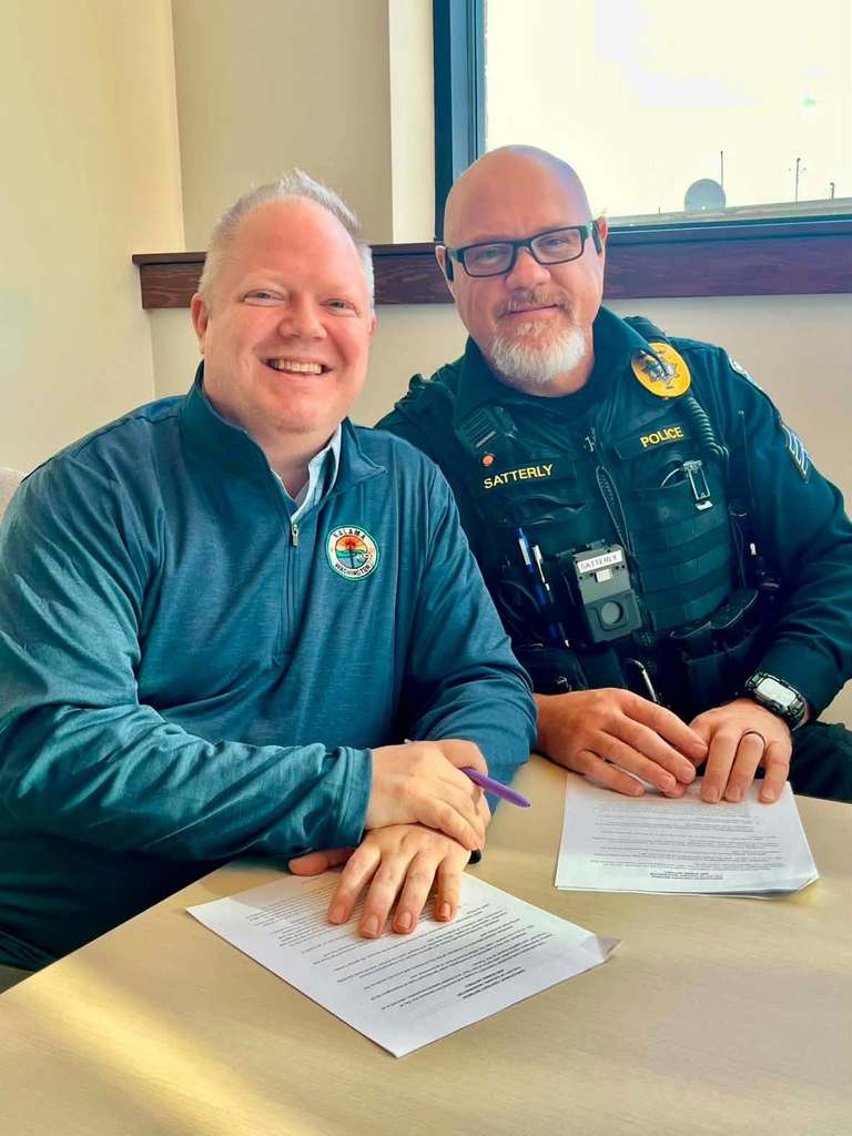 Mayor Stanfill and new Police Chief Robby Satterly signing paperwork for Police Chief position