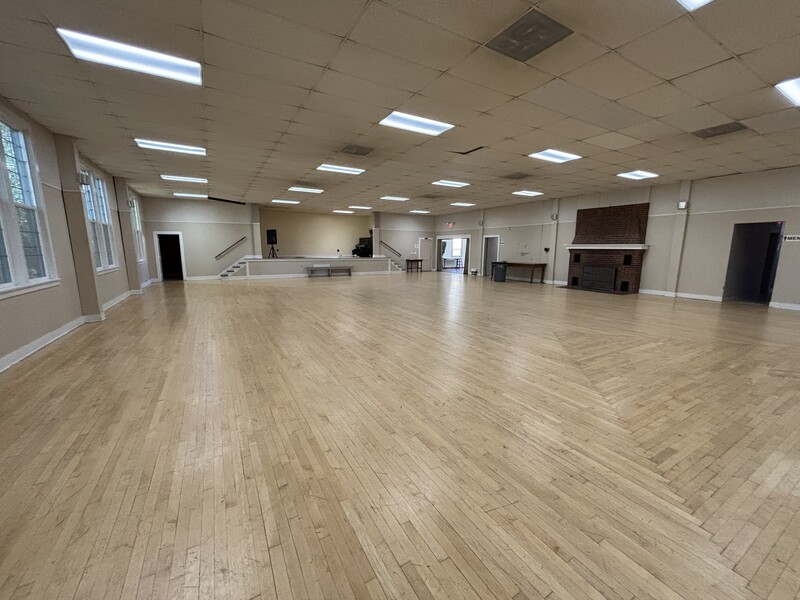 ballroom with stage, storage closets, and fireplace
