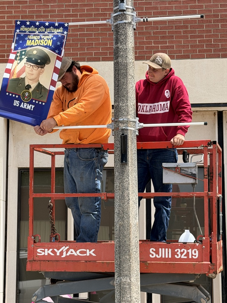 line crew hanging veterans banners