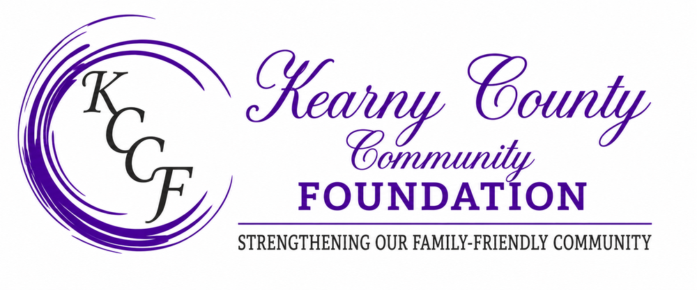 cover photo for the Kearny County Community Foundation featuring a clean white background with purple branding. On the left is the KCCF logo, consisting of stylized black letters “KCCF” inside a circular purple brushstroke design. To the right, elegant purple script text reads “Kearny County Community”, with “FOUNDATION” displayed prominently in bold purple lettering underneath. A thin purple line separates the title from the tagline below, which reads: “STRENGTHENING OUR FAMILY-FRIENDLY COMMUNITY.” The overall design is clean, professional, and community-focused with a purple and black color palette.