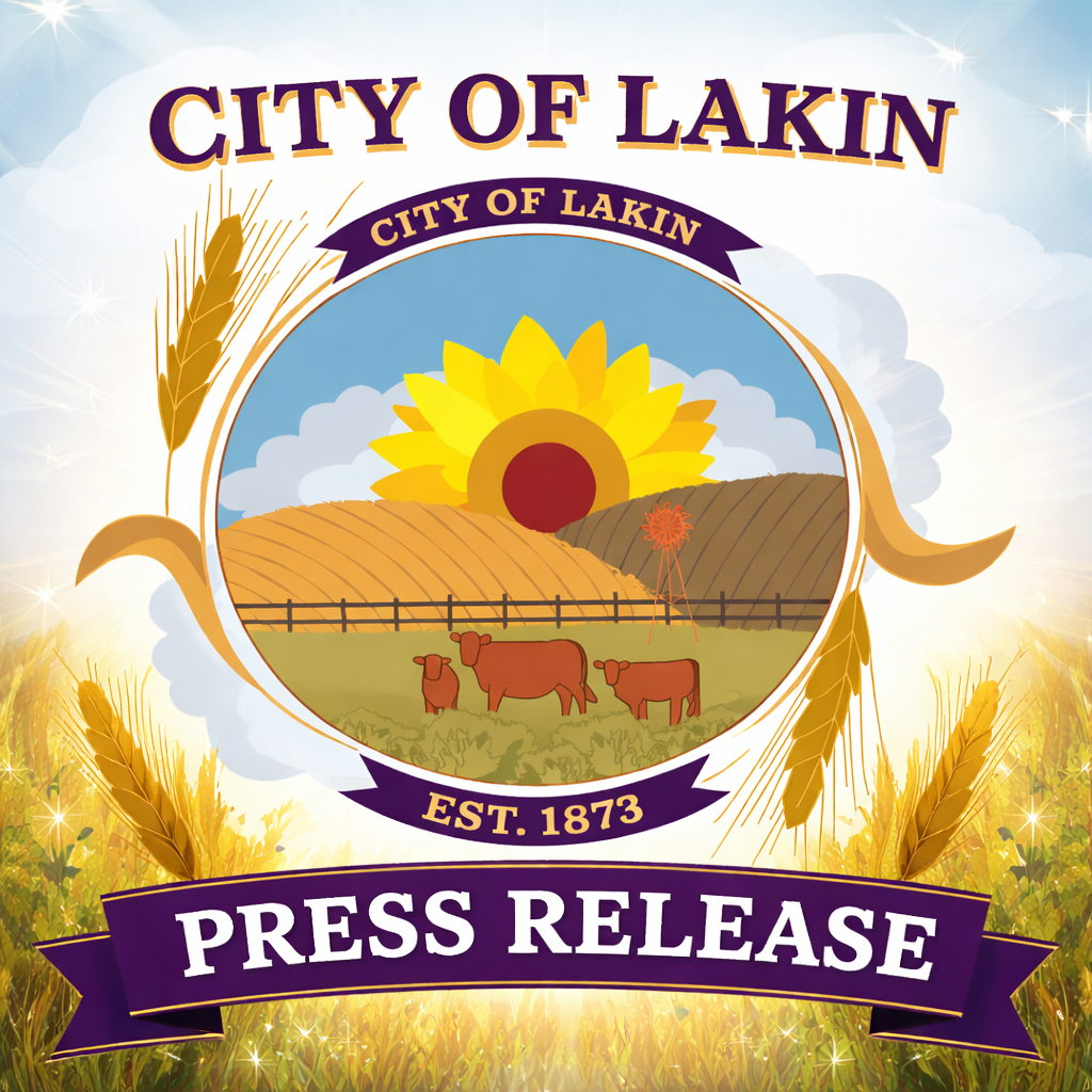 Square City of Lakin press release graphic featuring the official City of Lakin logo centered prominently against a soft sky background. Large bold purple-and-gold text at the top reads “CITY OF LAKIN,” and a purple ribbon banner at the bottom reads “PRESS RELEASE” in white lettering. The design includes golden wheat stalks and a warm field scene that complements the city’s agricultural logo and branding colors.