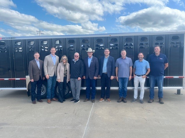Governor and First Lady Rhoden, Lt. Governor Venhuizen, Mayor Fergen, and leadership from Wilson Trailer pose in front of a livestock trailer