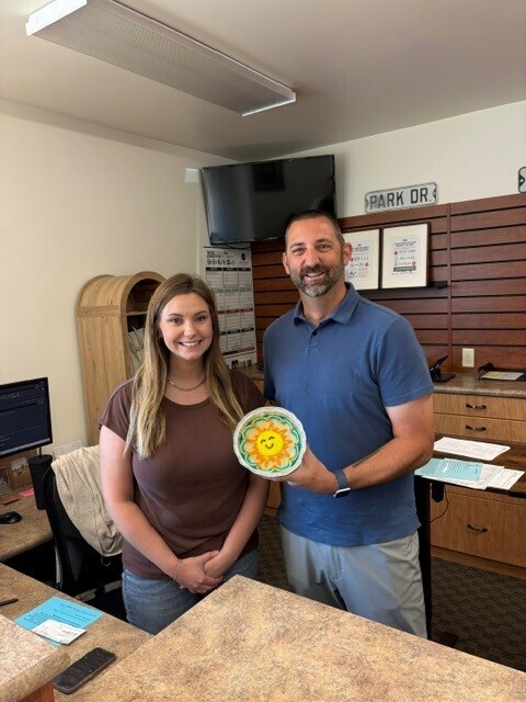 A photo of Jess Severson being presented with a sunshine cookie