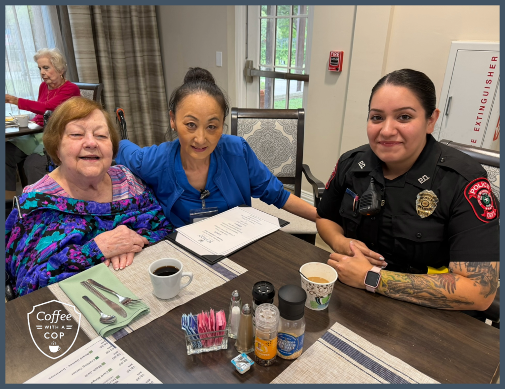 A Meadows Place police officer poses for a photo with a resident and a staff member at The Jasper of Meadows Place during Coffee with a Cop.