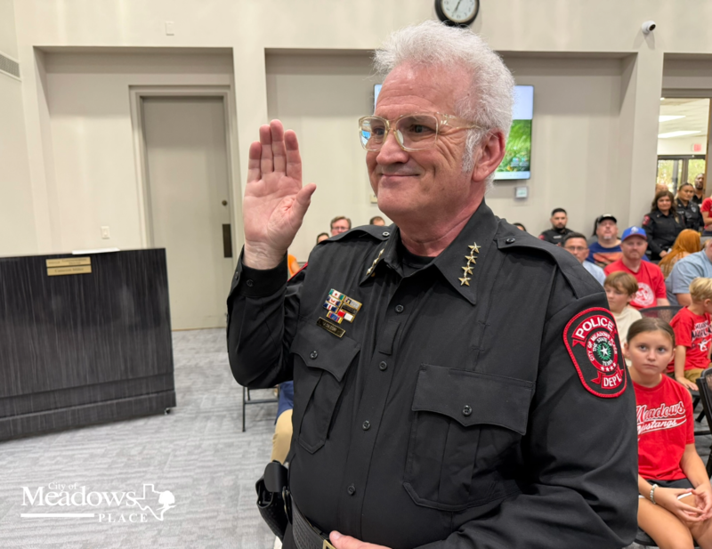 Police Chief Jack Ashton raises his right hand while taking the oath of office during his swearing in ceremony at City Hall.