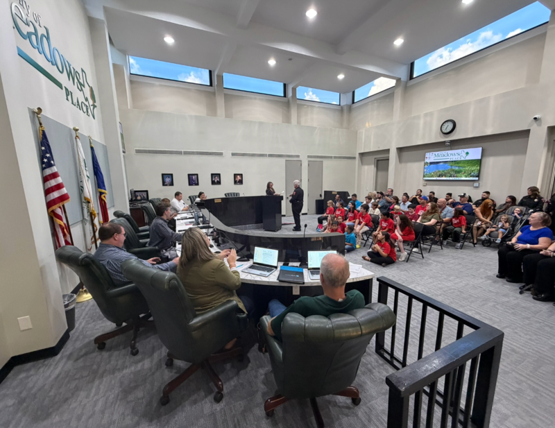 Mayor St. Germain administers the oath of office to Police Chief Jack Ashton during the City Council meeting as Council and attendees look on.