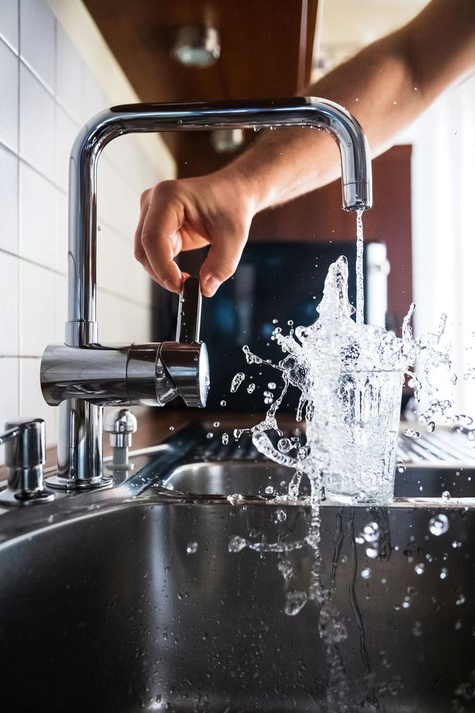 faucet running into a glass of water