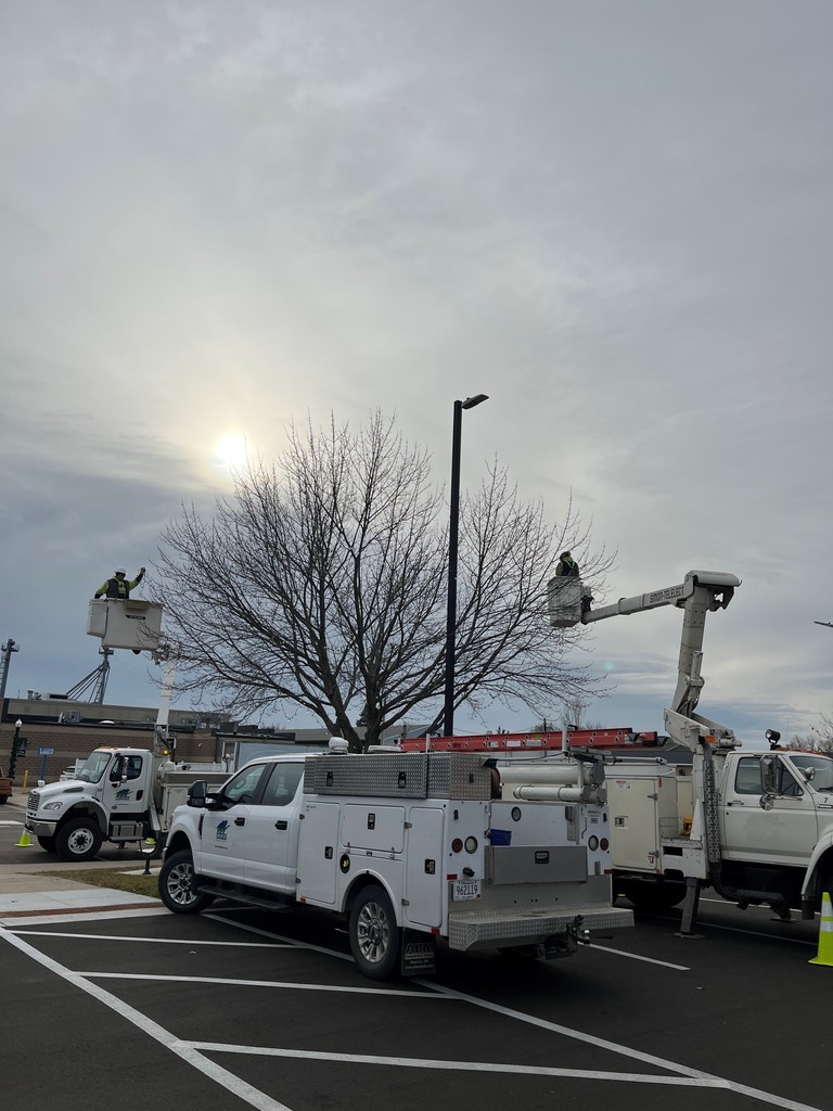 Line department in bucket trucks putting up holiday lights