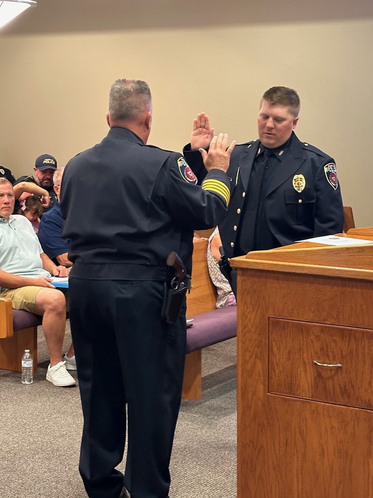 Officer Jake Baker receiving the Oath of Office from Chief Wallace