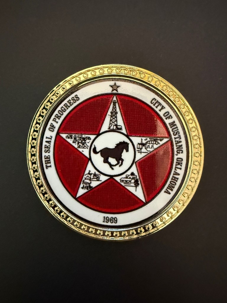 One side of a Coin with the City of Mustang Seal on it